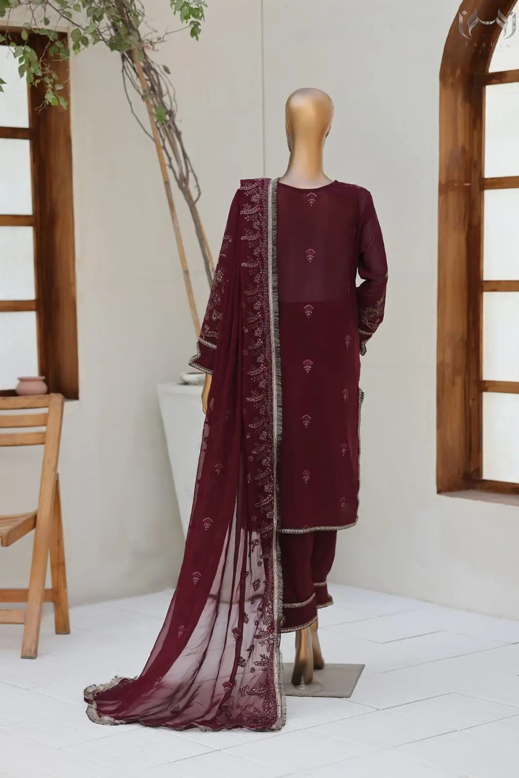 Maroon traditional outfit with a sheer dupatta on a mannequin against a neutral background.