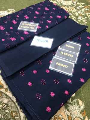 Navy blue fabric with pink floral pattern on a green patterned surface