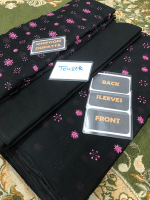 Black dupatta with pink floral patterns on a green fabric background