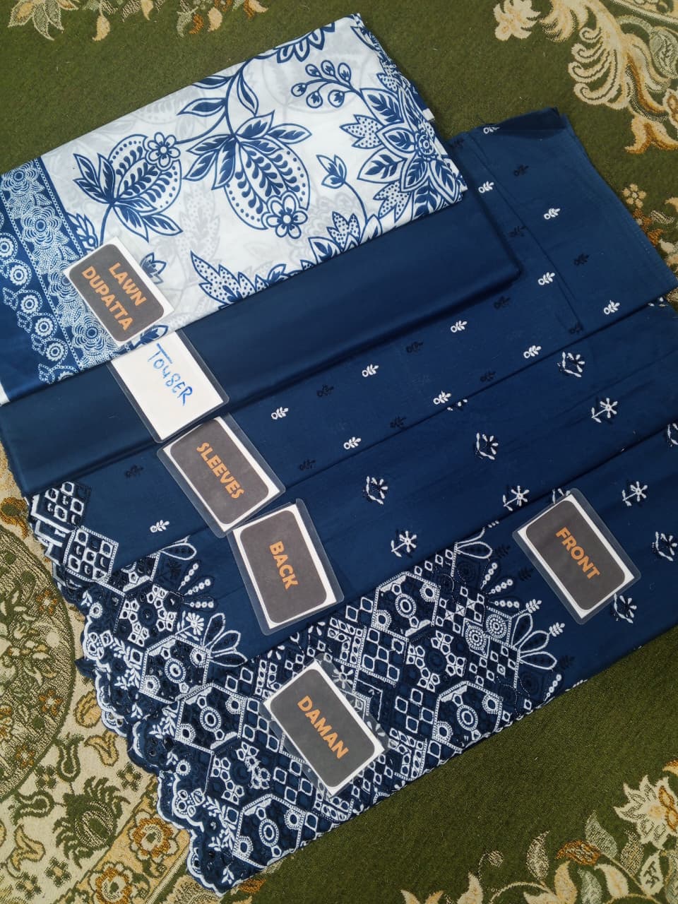 Set of blue bandanas with white patterns on a green fabric background