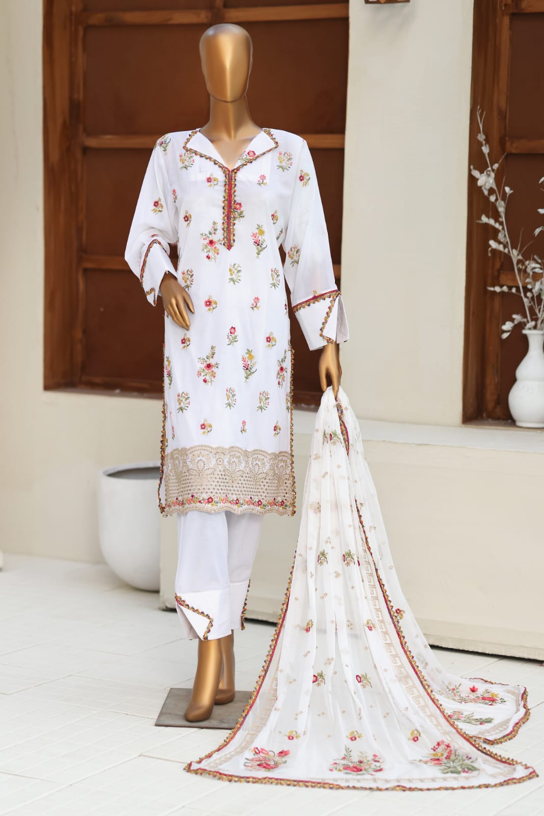 White embroidered outfit with matching dupatta on a mannequin against a neutral background