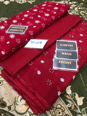 Red fabric with white patterns on a green patterned surface, labeled with 'Shefoon Dupatta'.