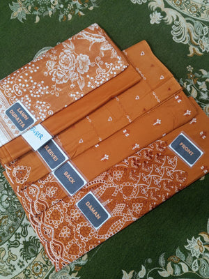 Set of orange patterned fabric pieces with labels on a green floral background